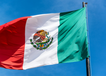 Bandera de México ondeando contra un cielo azul claro