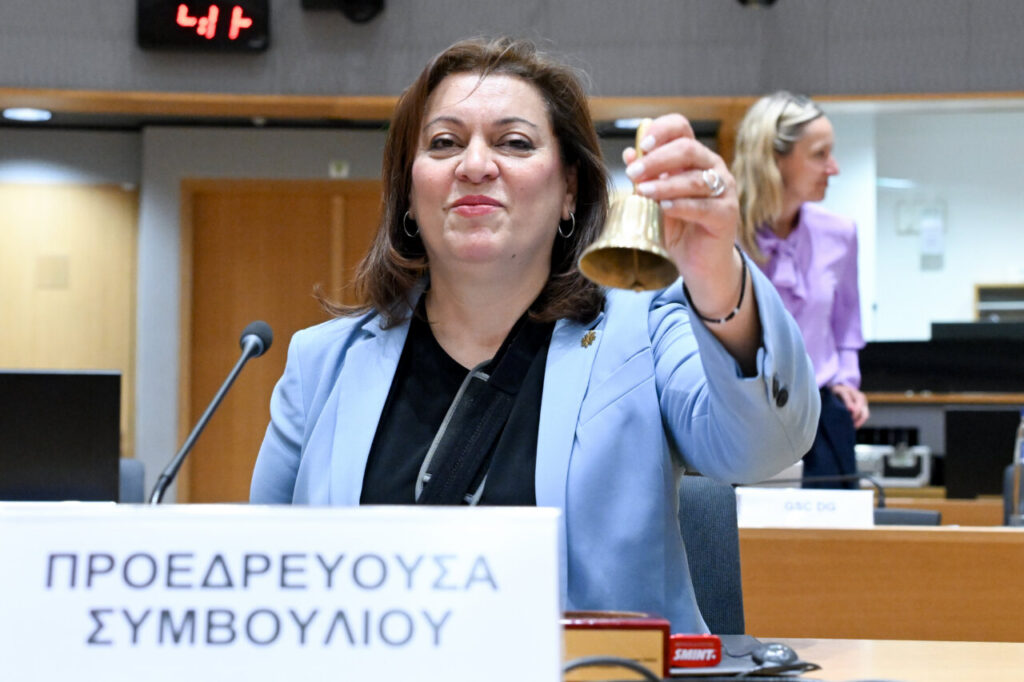 Miembro del Consejo de la Unión Europea sosteniendo una campana durante una reunión