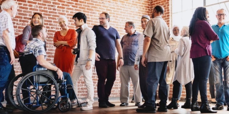 Grupo diverso de personas sonriendo y conversando en un ambiente inclusivo