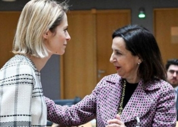 La ministra de Defensa de España interactuando con una colega en una reunión
