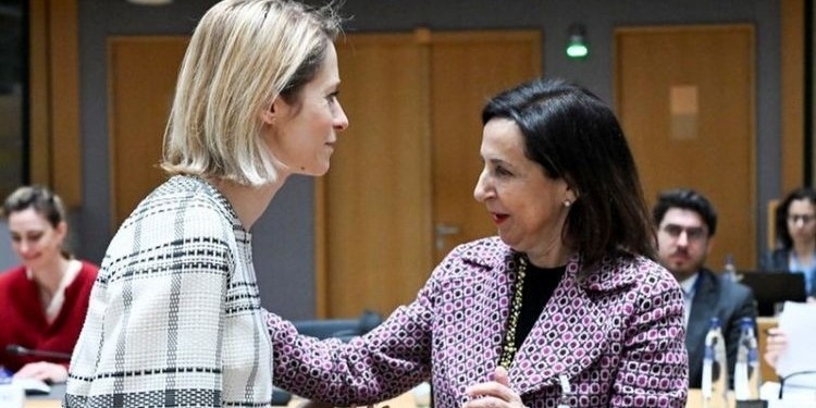 La ministra de Defensa de España interactuando con una colega en una reunión