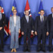 Cinco líderes europeos posando frente a banderas en un evento formal.