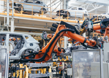 Brazos robóticos automatizados soldando estructuras de coches en una fábrica