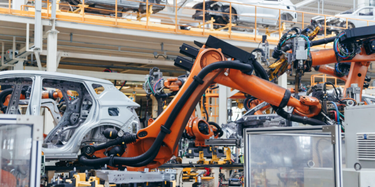 Brazos robóticos automatizados soldando estructuras de coches en una fábrica