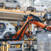 Brazos robóticos automatizados soldando estructuras de coches en una fábrica