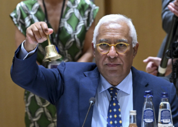 Persona levantando una campana durante una reunión del Consejo Europeo