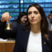 Ministra sosteniendo una campana durante la reunión del Consejo de Asuntos Generales