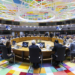 Reunión del G7 en un colorido salón con líderes europeos discutiendo