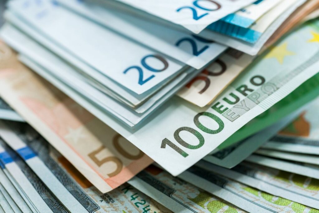 Billetes de euro y dólar apilados en un fondo