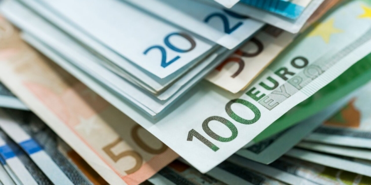 Billetes de euro y dólar apilados en un fondo