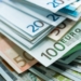 Billetes de euro y dólar apilados en un fondo