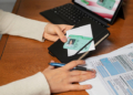 Persona revisando documentos de identidad sobre una mesa de trabajo