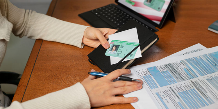 Persona revisando documentos de identidad sobre una mesa de trabajo