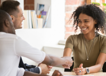 Tres personas en una reunión discutiendo sobre empleo y mercado laboral
