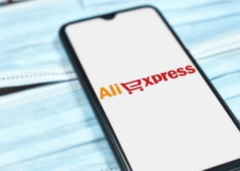 Teléfono móvil mostrando el logo de AliExpress sobre una superficie de mascarillas.