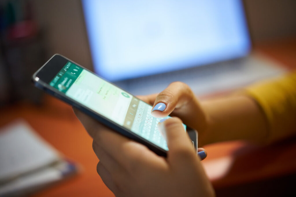 Manos utilizando un smartphone para comunicarse en el trabajo