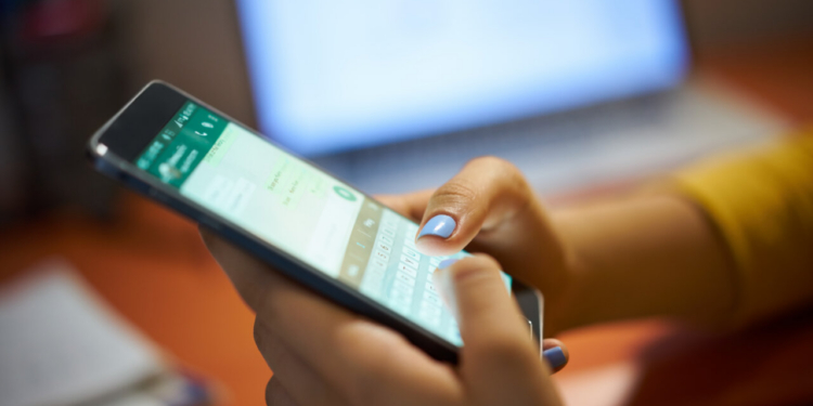 Manos utilizando un smartphone para comunicarse en el trabajo