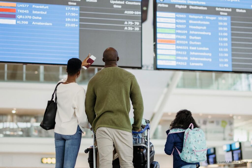 Familia observando la pantalla de salidas en un aeropuerto