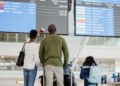 Familia observando la pantalla de salidas en un aeropuerto