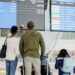 Familia observando la pantalla de salidas en un aeropuerto