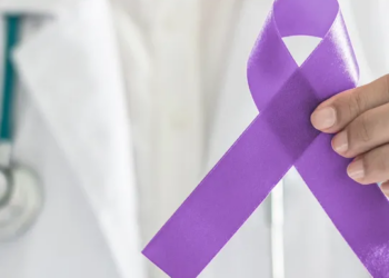 Médico sosteniendo un lazo morado en apoyo al cáncer de páncreas