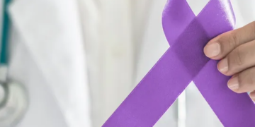 Médico sosteniendo un lazo morado en apoyo al cáncer de páncreas