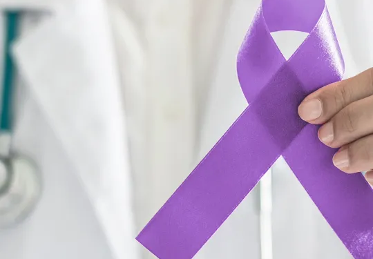 Médico sosteniendo un lazo morado en apoyo al cáncer de páncreas