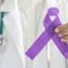 Médico sosteniendo un lazo morado en apoyo al cáncer de páncreas