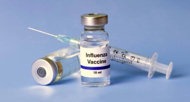 Frascos de vacuna contra la influenza y una jeringa