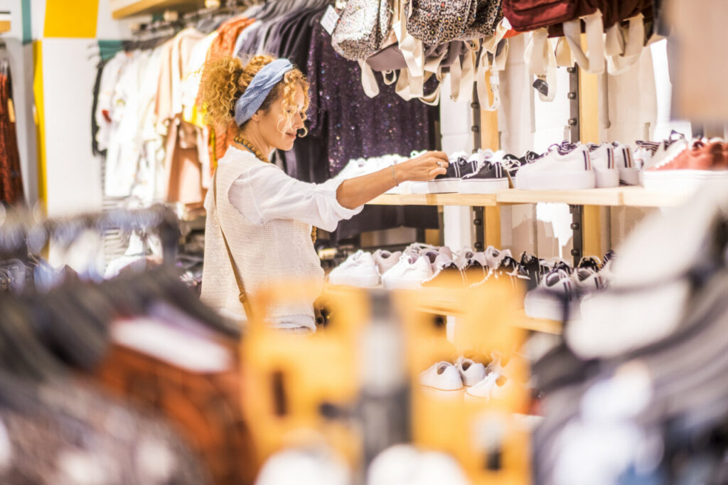 Mujer joven revisando ropa en una tienda de moda