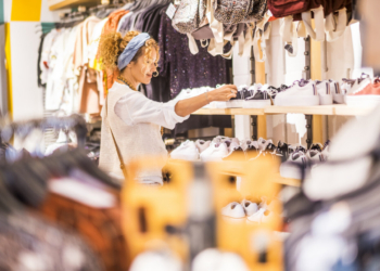 Mujer joven revisando ropa en una tienda de moda