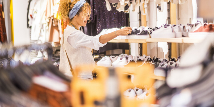 Mujer joven revisando ropa en una tienda de moda